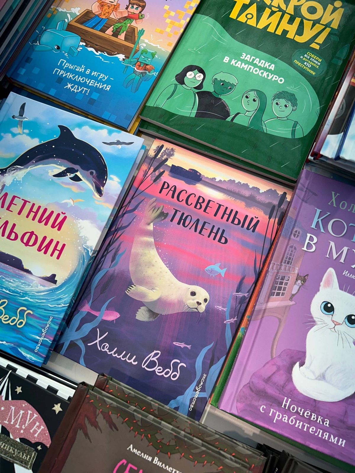 Выкладка детских книг на стенде издательства: «Рассветный тюлень» и «Летний дельфин» Холли Вебб, детективы и комиксы