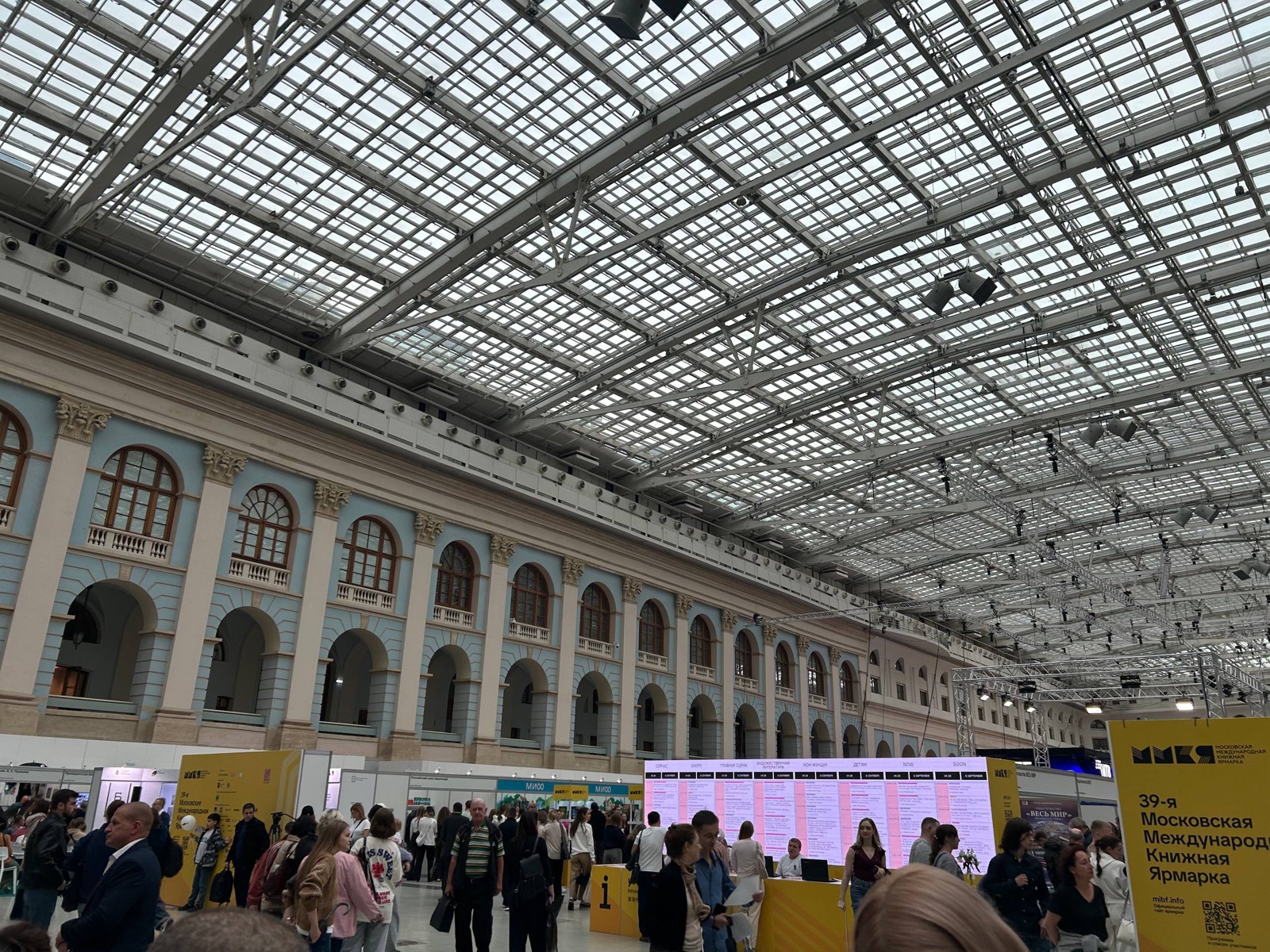 Зал Гостиного двора под стеклянной крышей во время 39-й Московской международной книжной ярмарки: стенды, расписание сцен, посетители